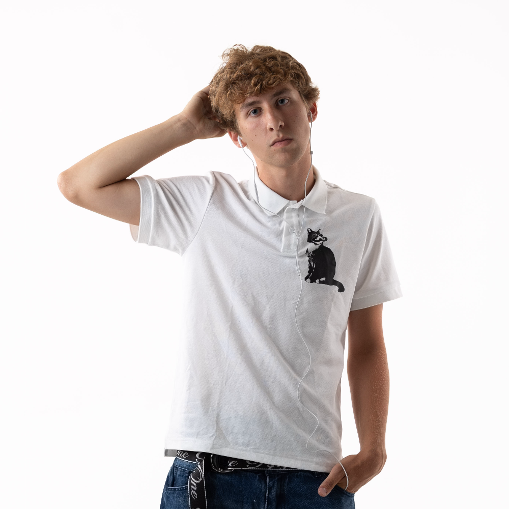 Person wearing a white polo shirt with a black cat graphic design on a white background