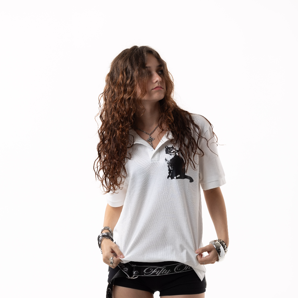 Woman wearing a white polo shirt with a black cat design on a white background