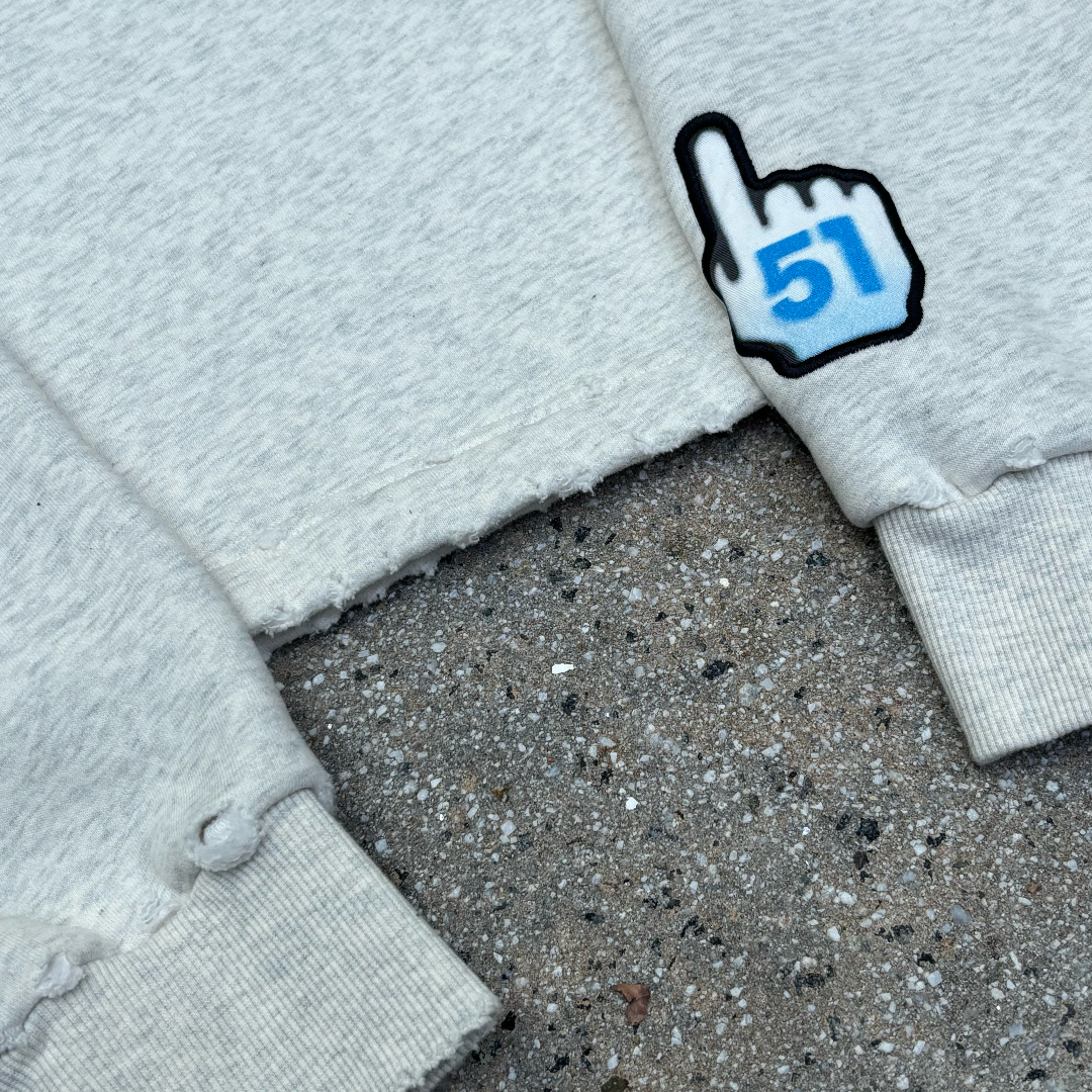 Gray fabric with a finger-like icon pointing to the number '51' on a concrete surface.